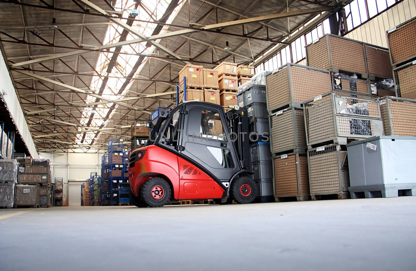 Forklift in a big warehouse with palettes