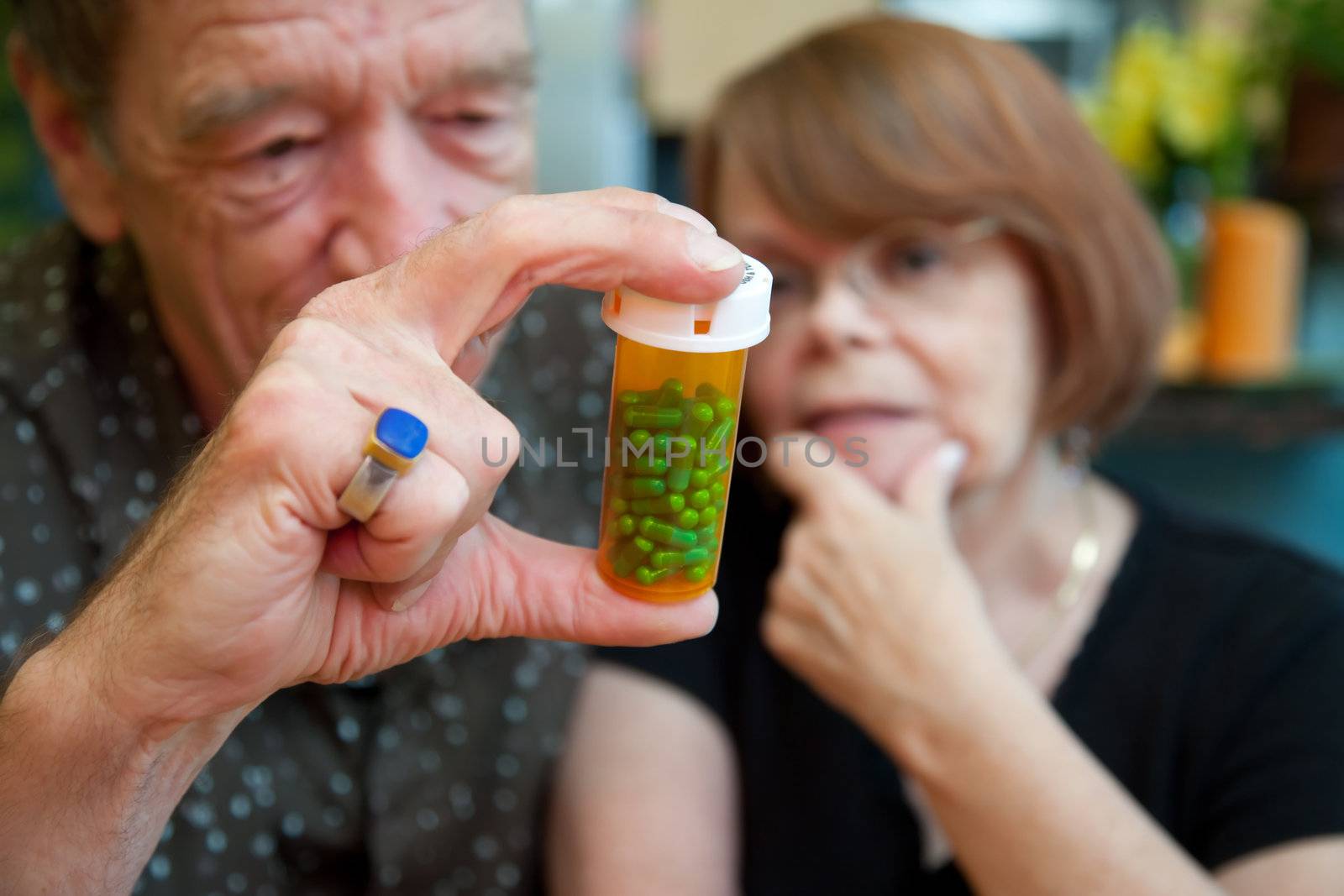 Senior couple at home with prescription bottle, focus