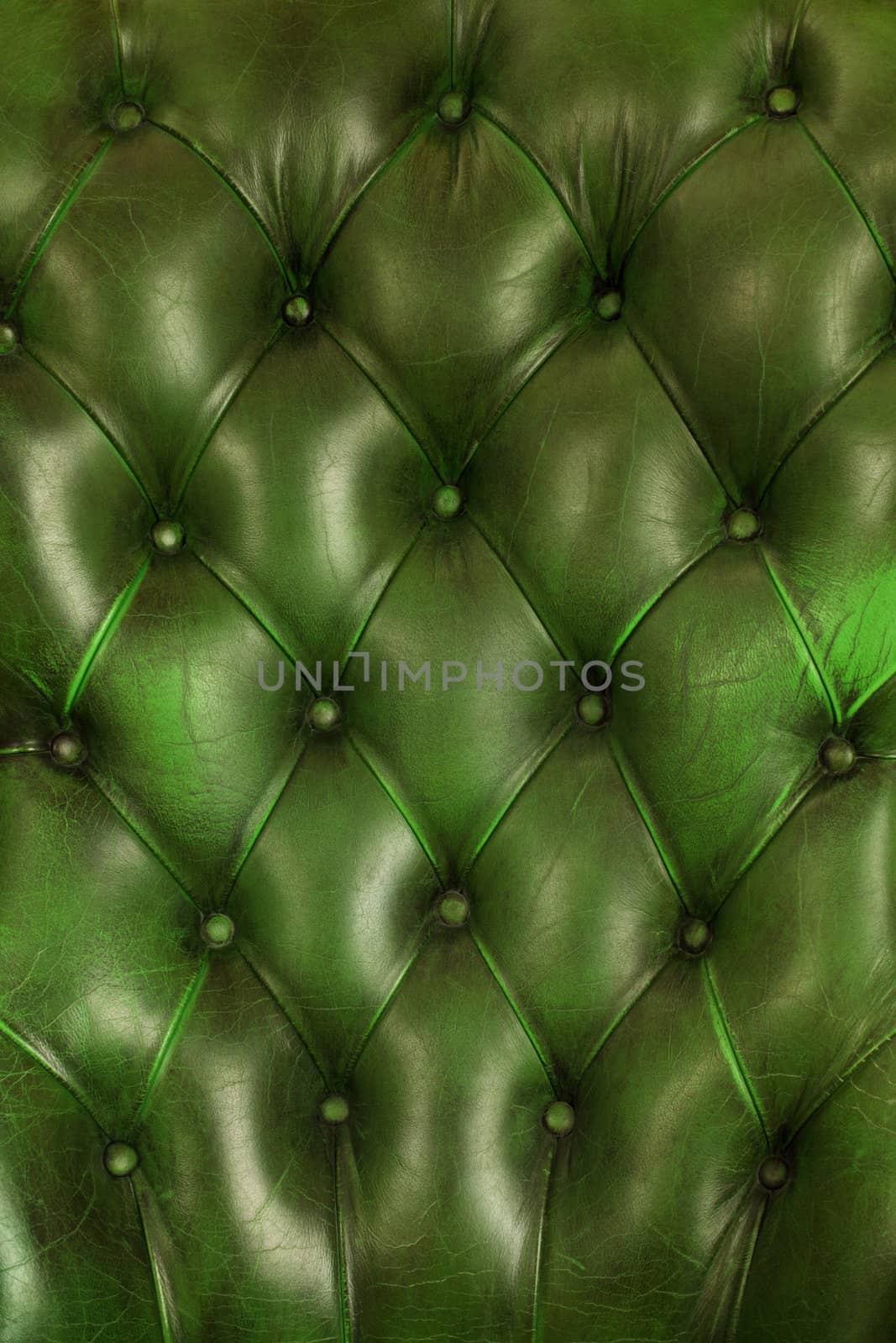 Photo of the old green leather upholstery of an antique chair.