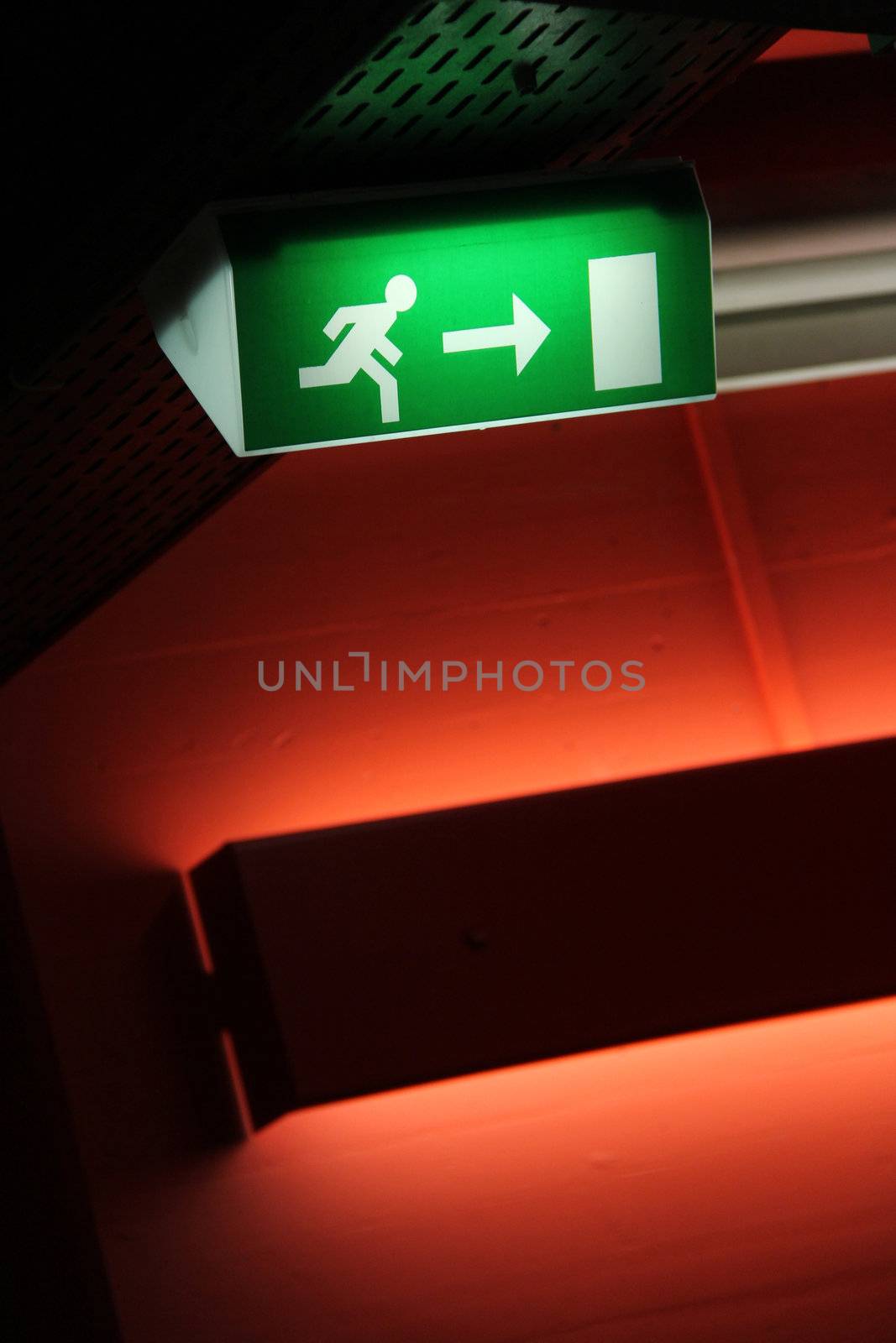 green emergency exit sign with red wall