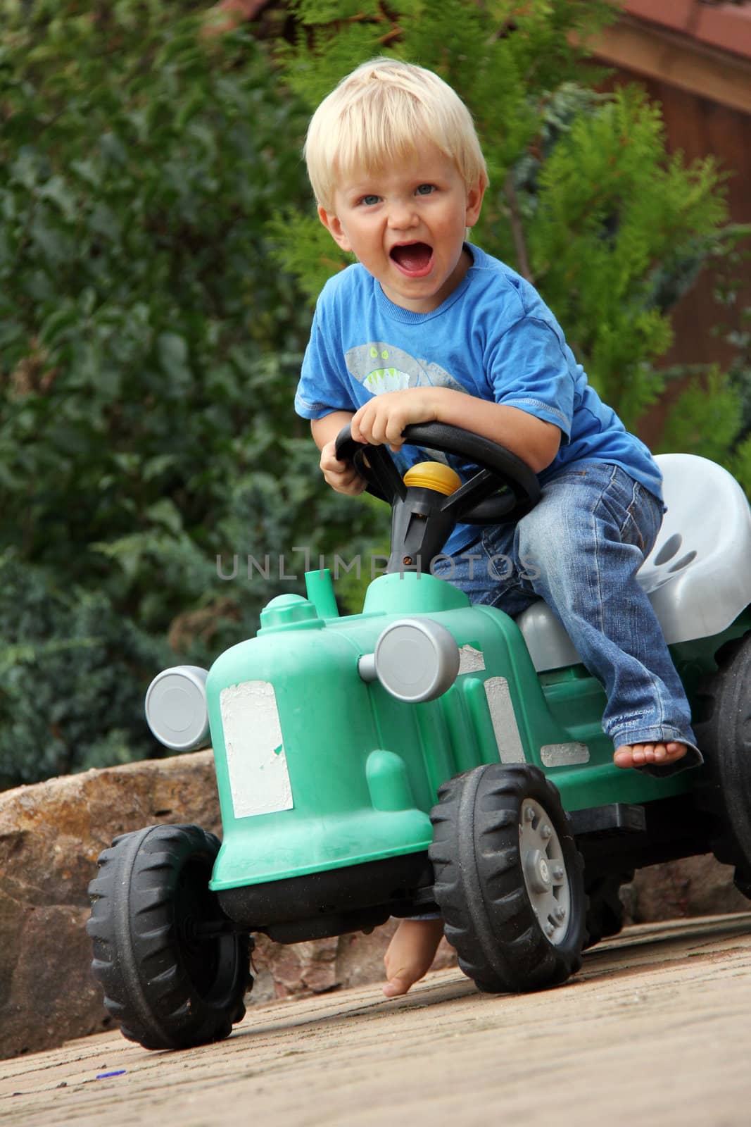 nice little blonde boy with green tractor toy