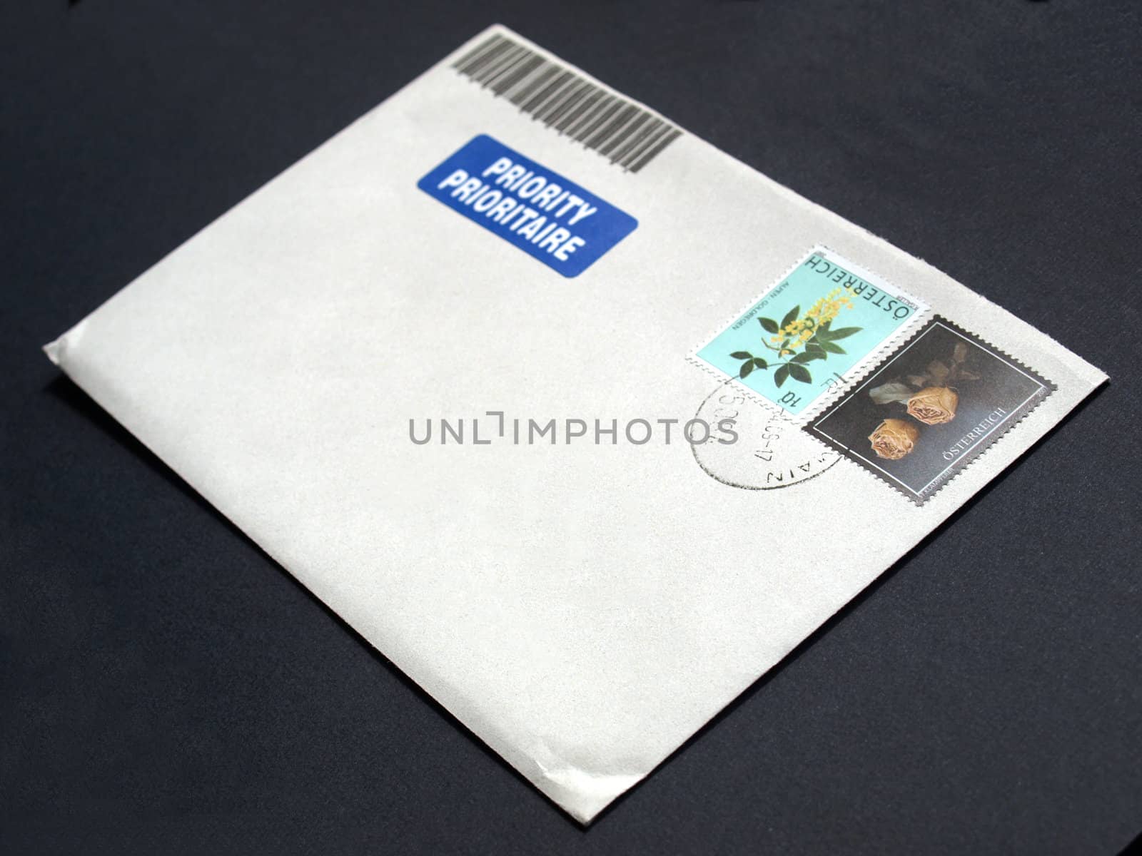 Letter envelope with postage meter and stamps