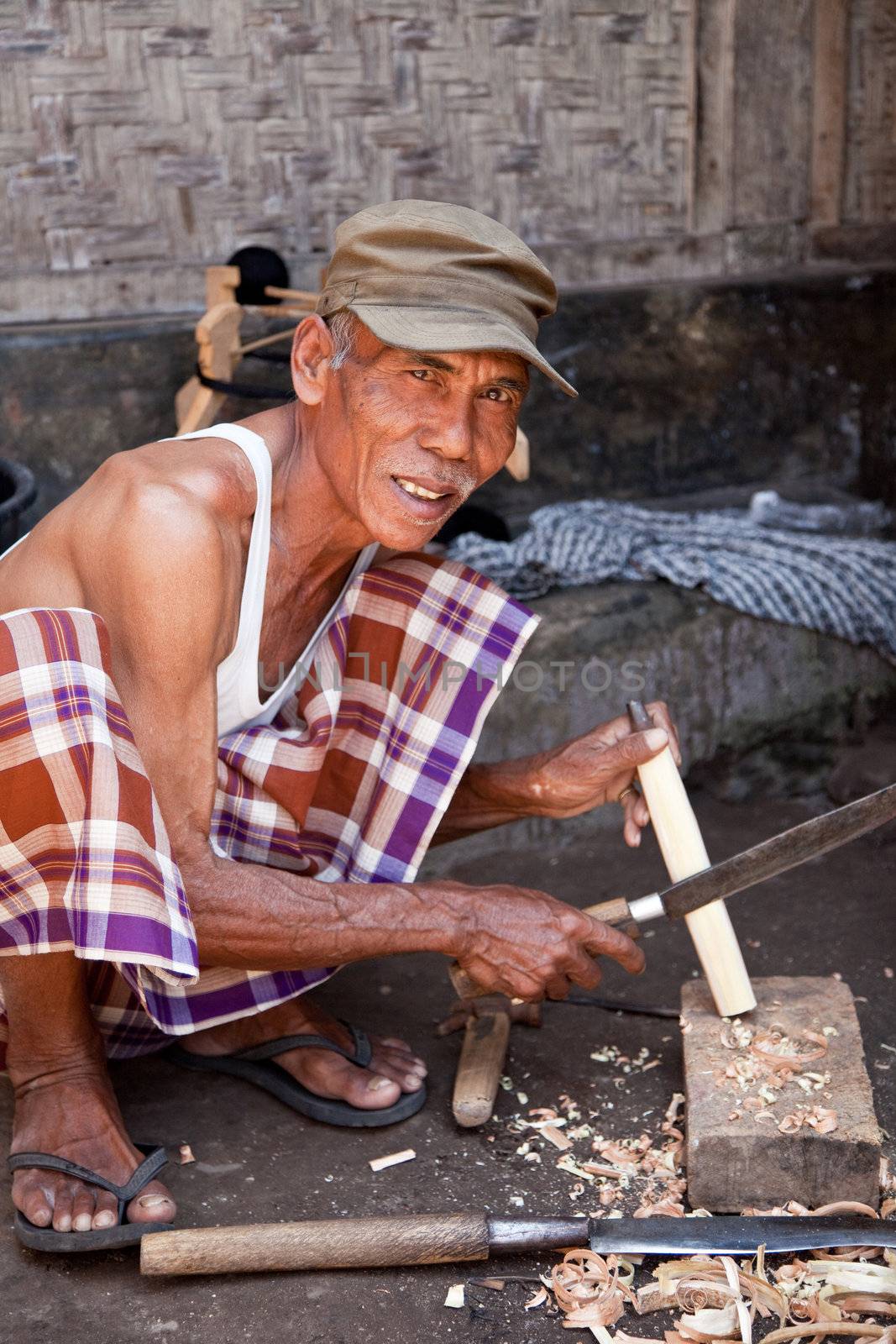 Elderly man working with a knife on a bambooshoot