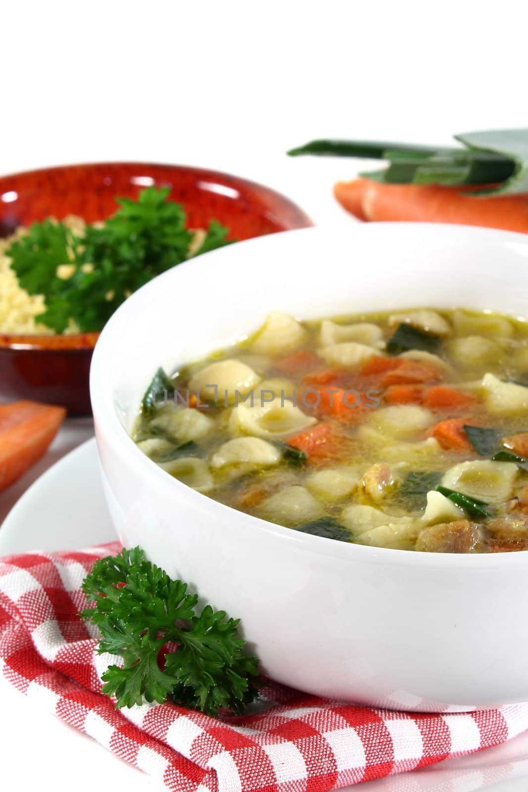 Chicken soup with vegetables and parsley in a bowl