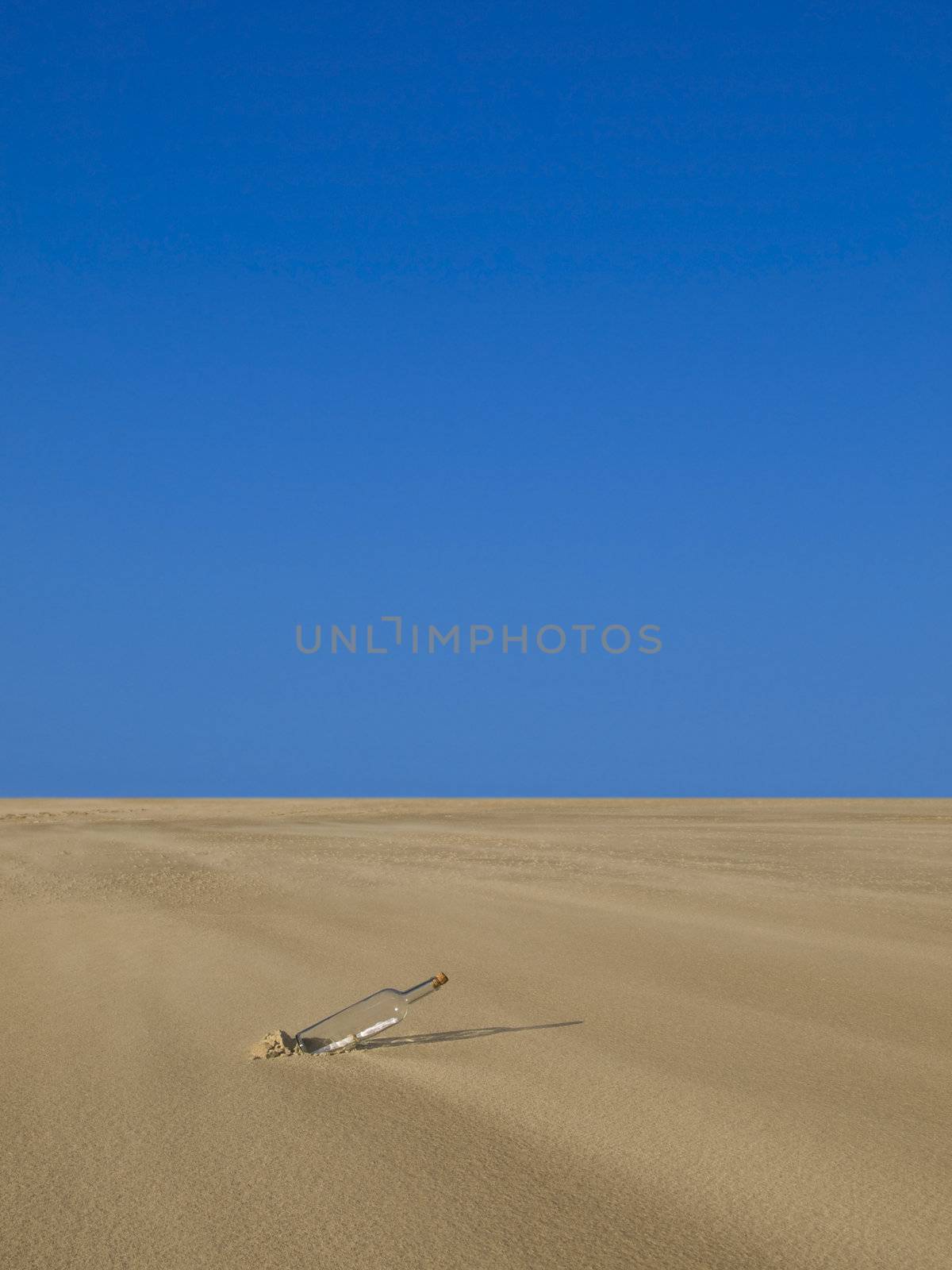 A bottle with a message inside is abandoned in the desert.