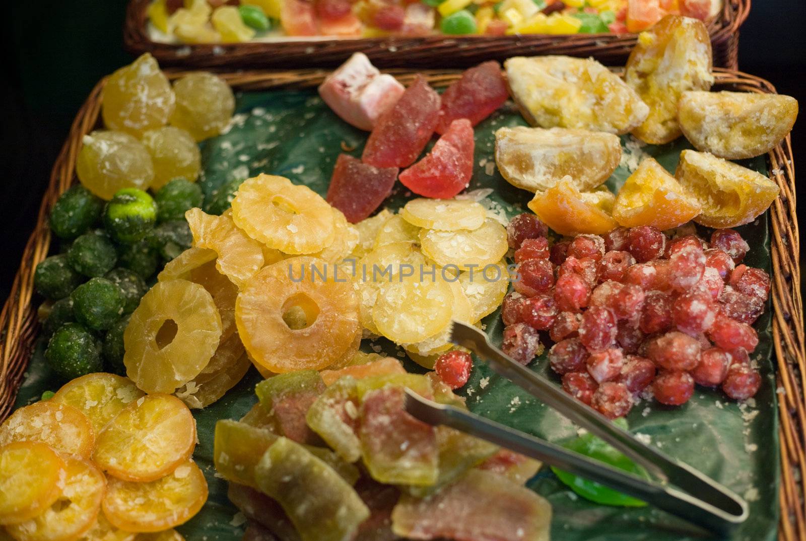 Basket in market stall with a colorful assortment of crystallized fruits. Shallow focus.