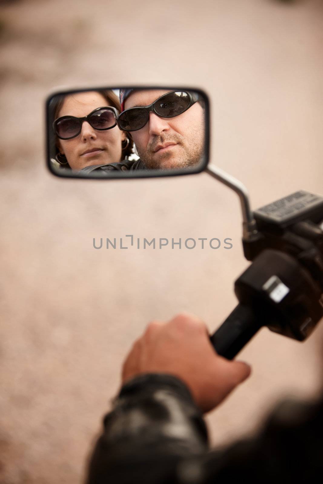 Reflection of Motorcycle Driver and Rider in Rearview Mirror