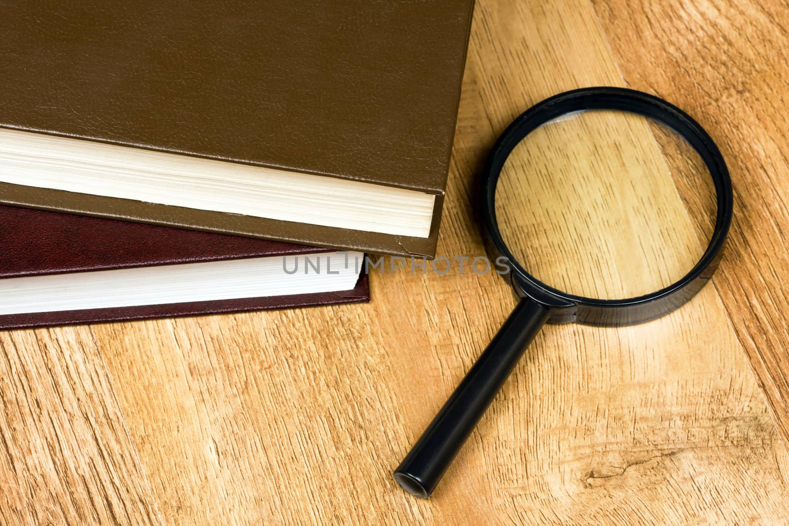 stack of books and magnifying glass