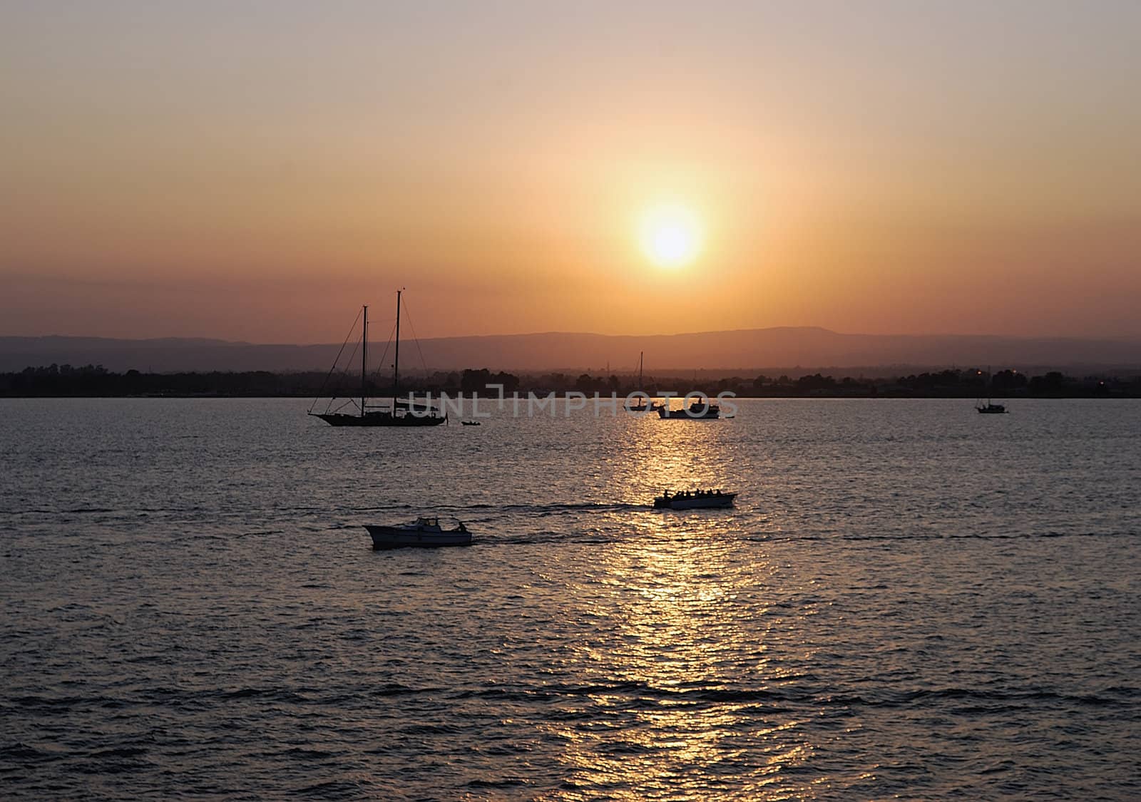 Ortigia island city of Siracusa (Italy) sunset with boats