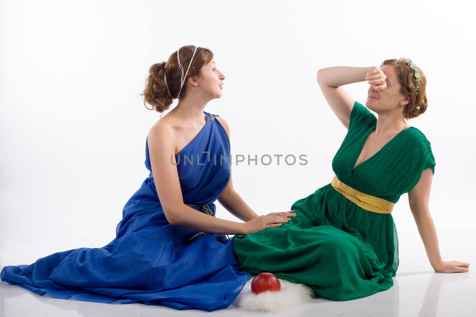 Two ladies in antique dress and apple on white background
