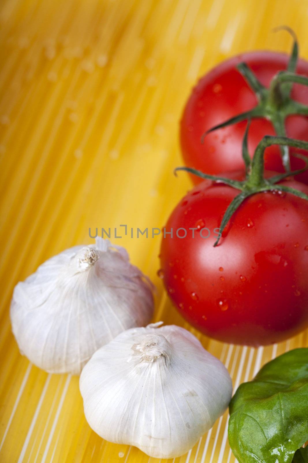 spaghetti, tomatoes, garlic and basil leaves