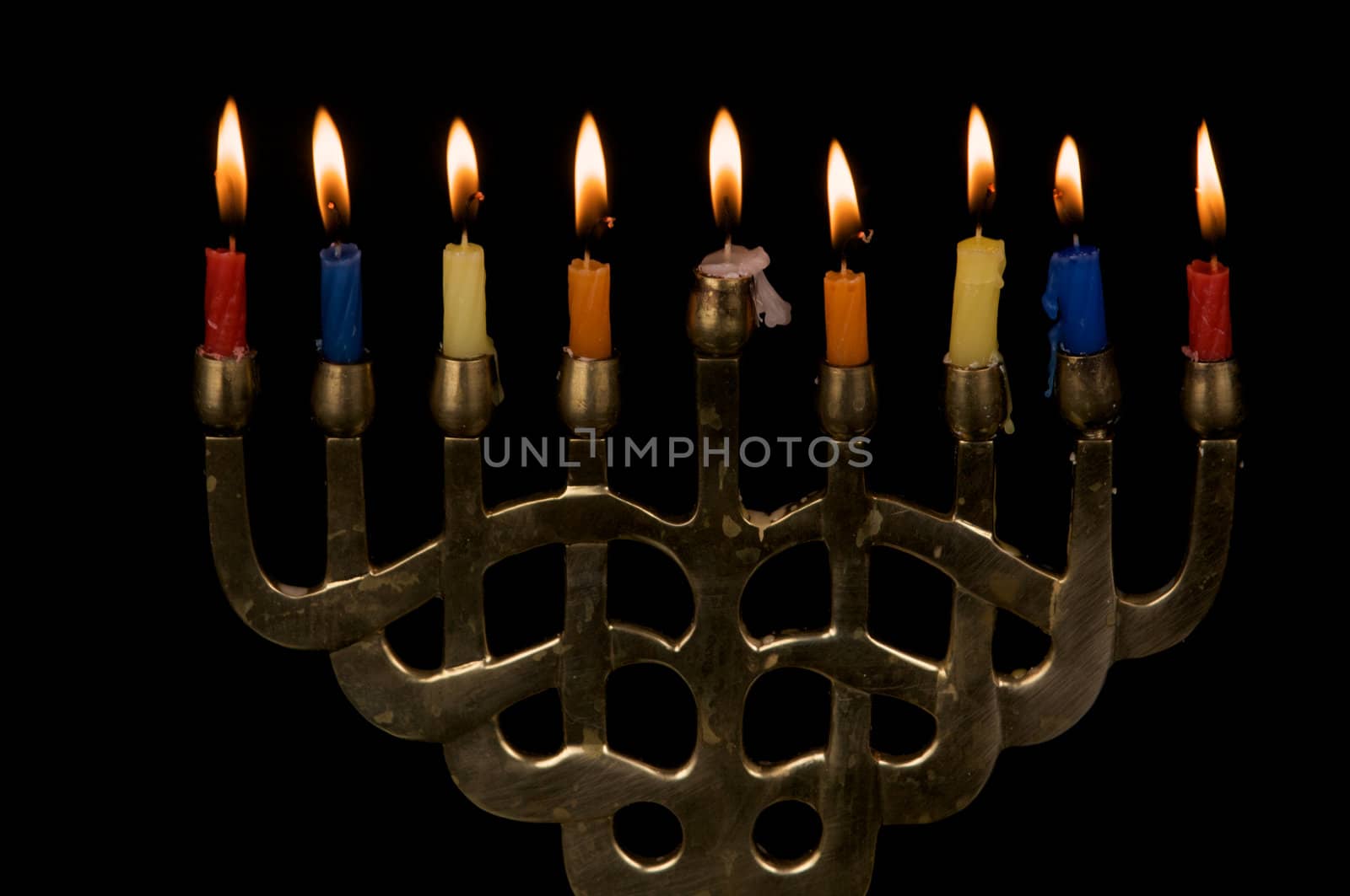 A gold colored menorak with lit Hanukah candles