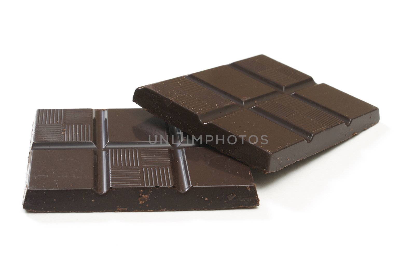 Two pieces of dark chocolate on white background.