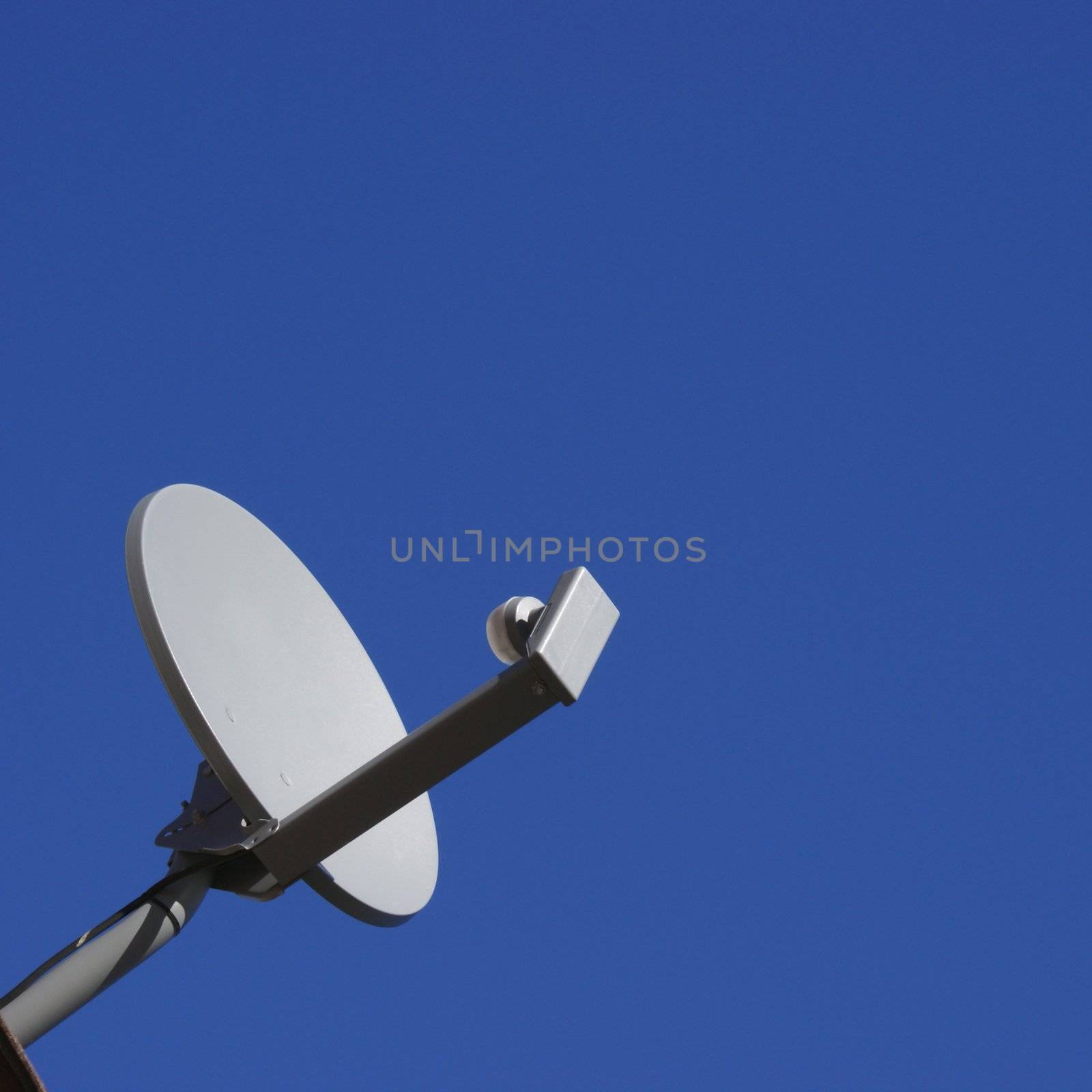 A satellite dish over a bright blue sky.