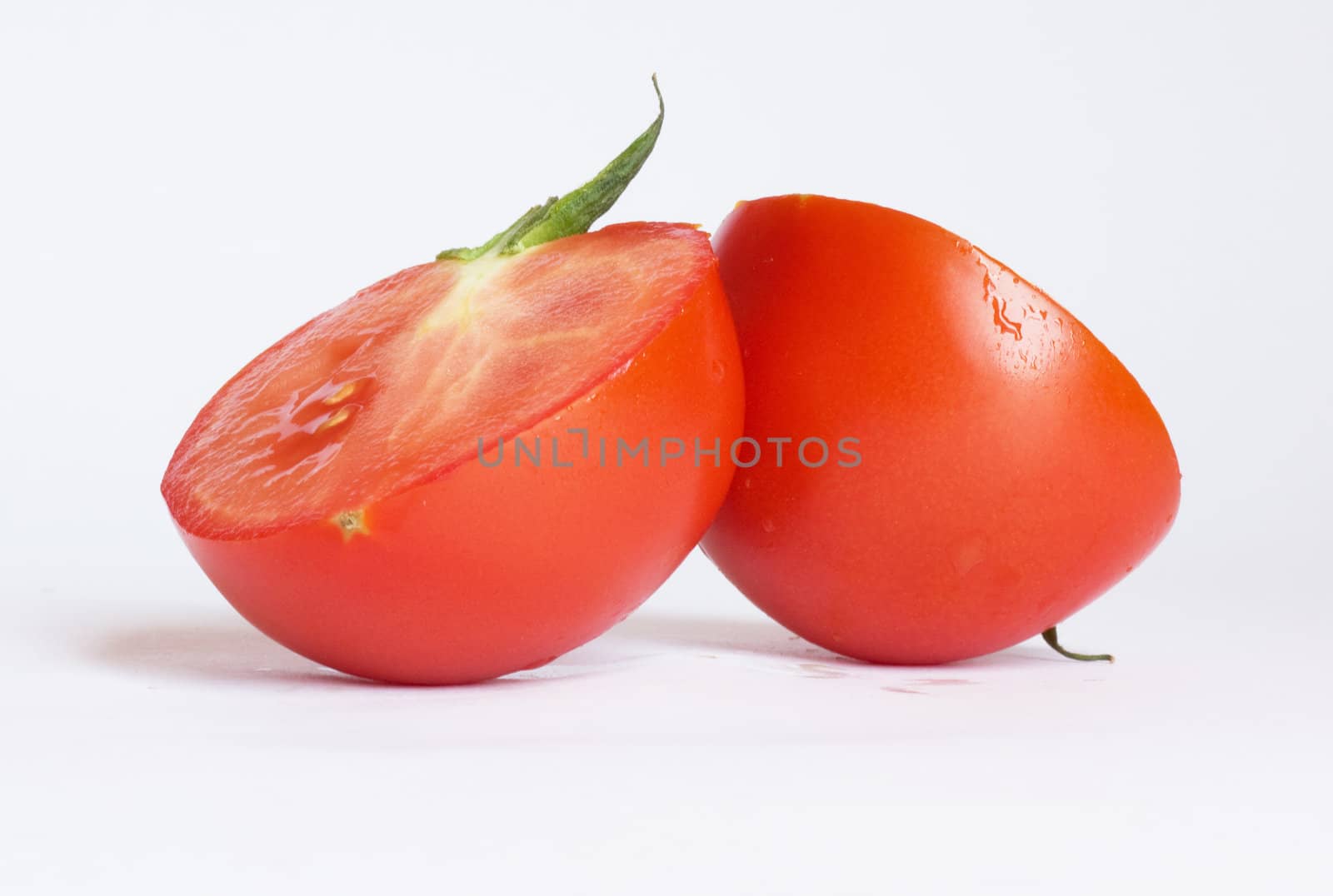 Two tomatoes isolated on white background  by schankz