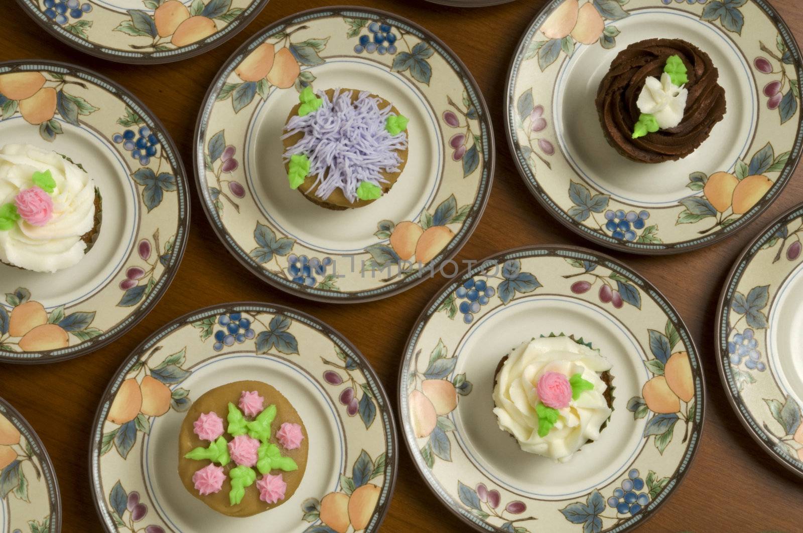 Close-up of ornately decorated cupcakes on plates