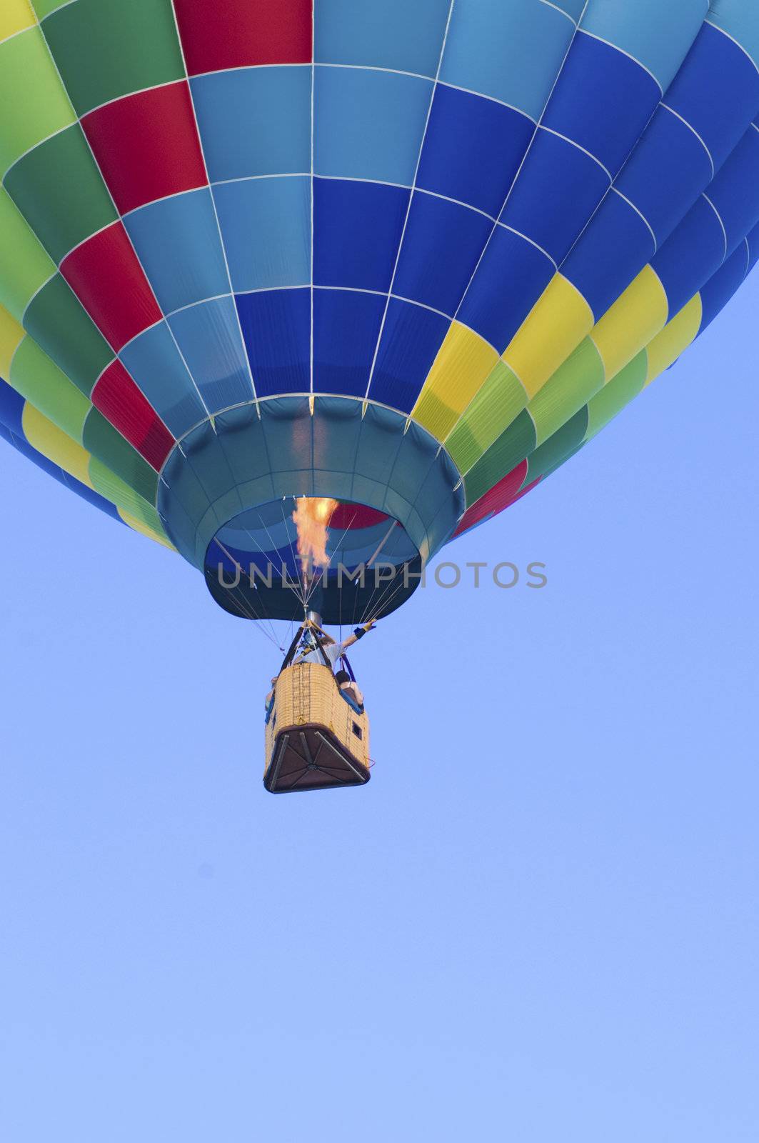 Hot-air balloon floating with view of gondola and burner ignition from below