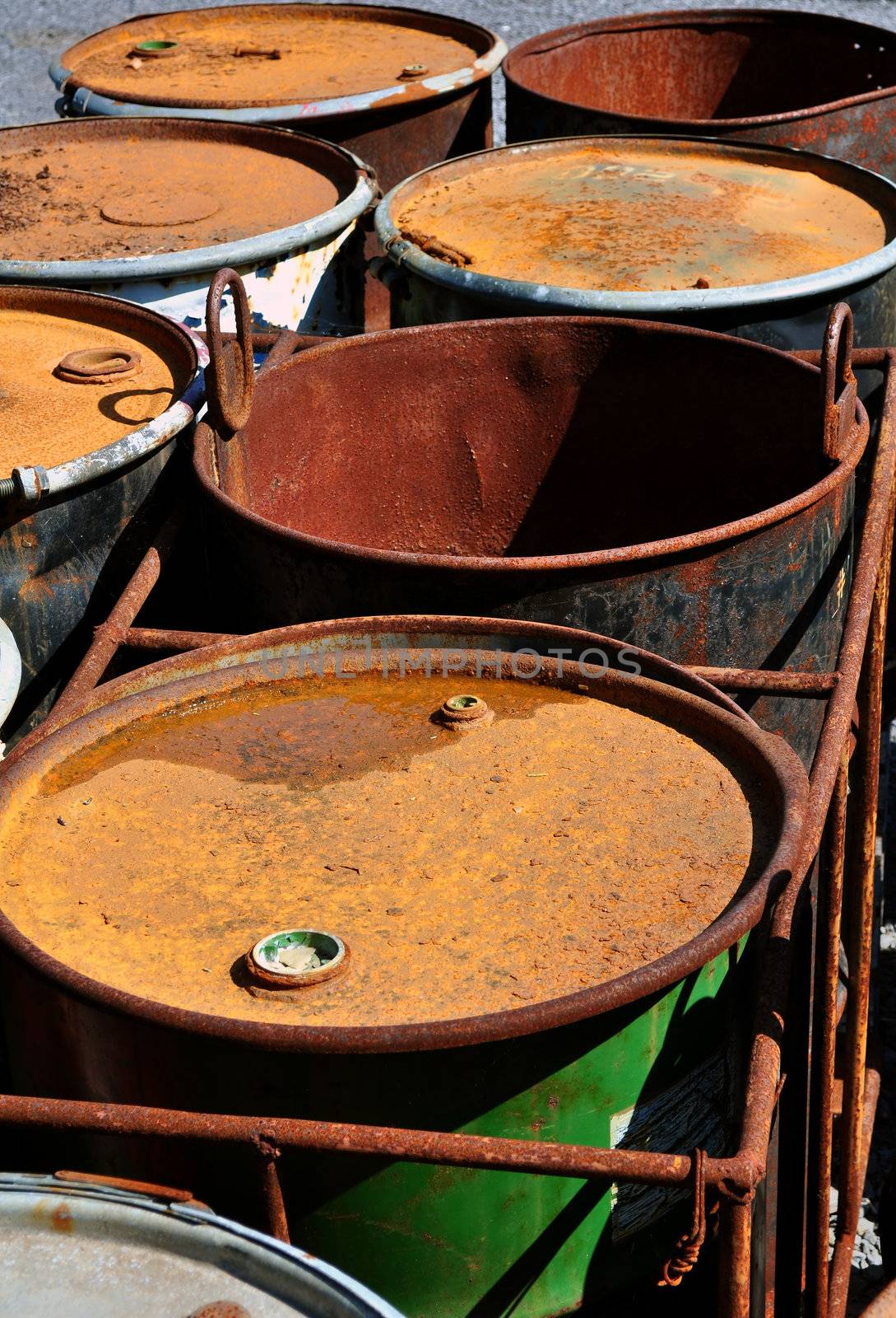 Old rusty 55-gallon fuel barrels corroding outside.