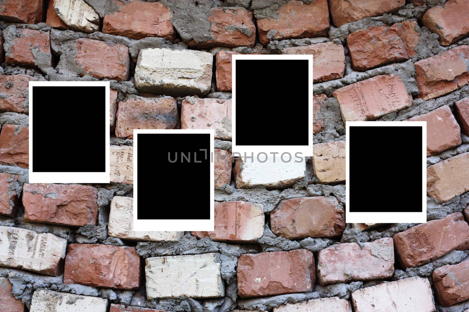 set of four old blank polaroids frames lying on a brick surface 