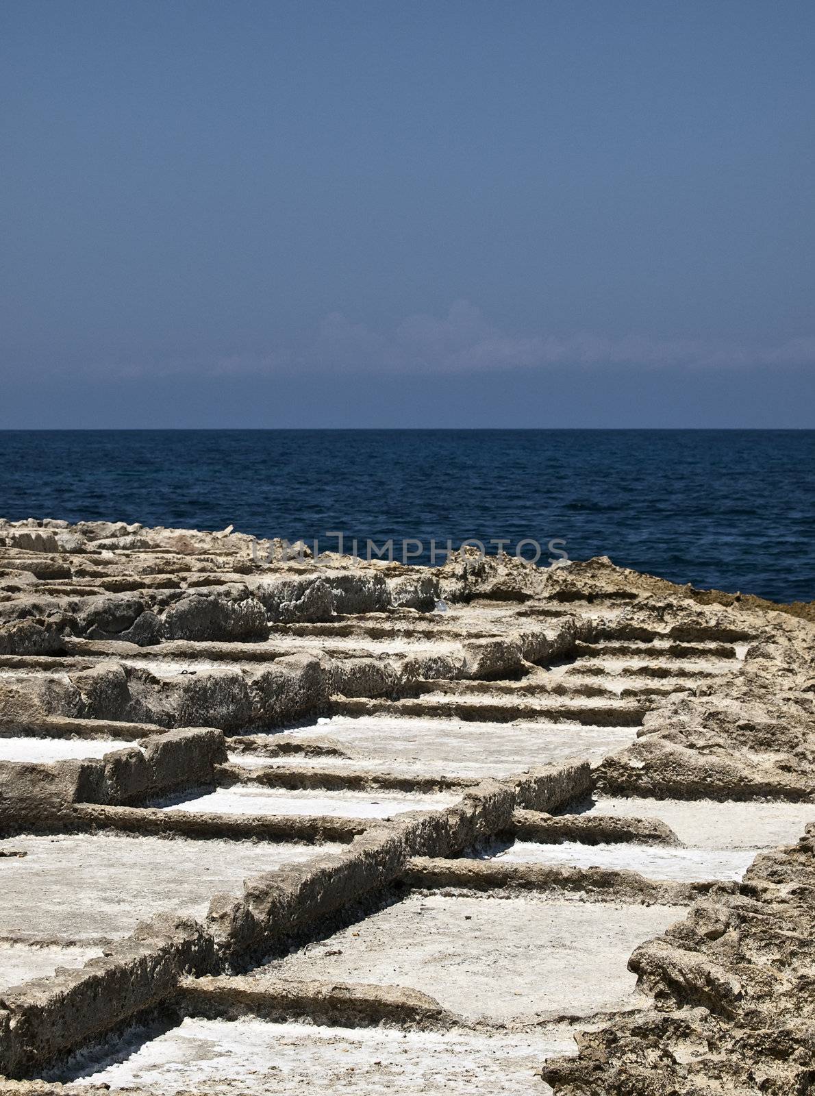 Ancient saltpanes from Roman times carved in sandstone in Qbajjar in Gozo