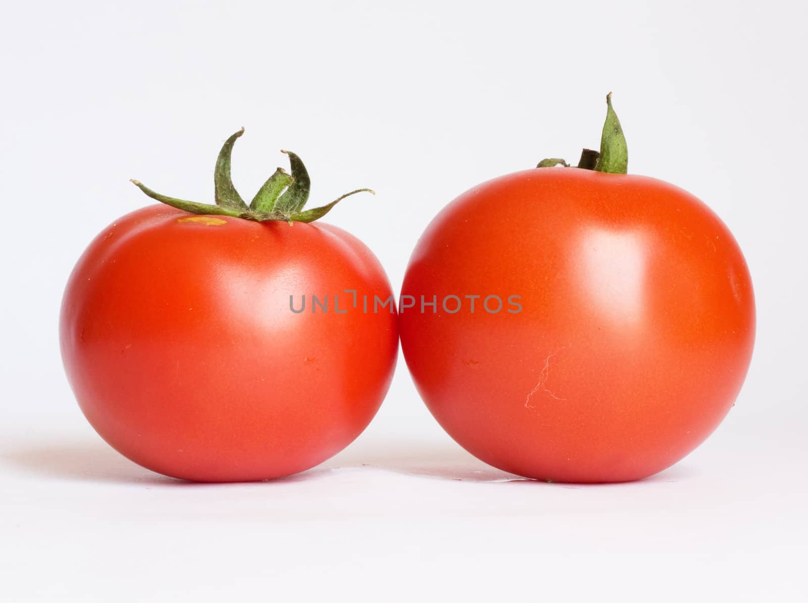 Two tomatoes isolated on white background 