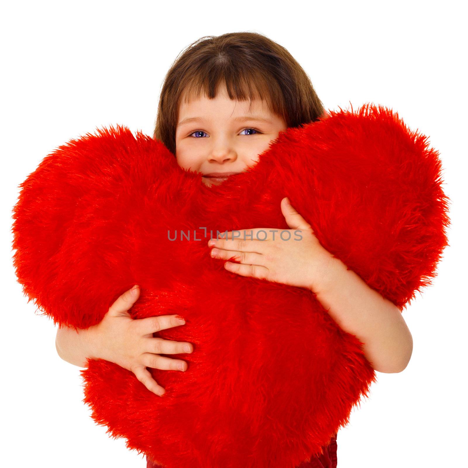 Little girl hugging a large toy heart isolated on white background