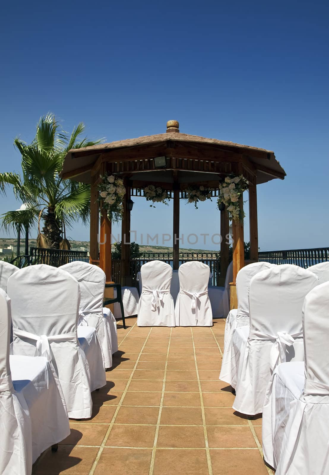 A Mediterranean wedding setting showing aisle and gazebo
