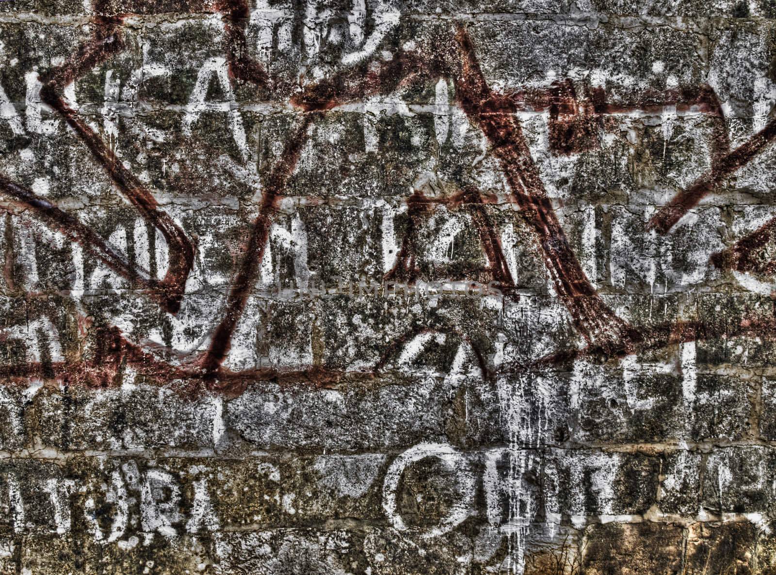 Graffiti and inscriptions on a limestone wall shot in HDR