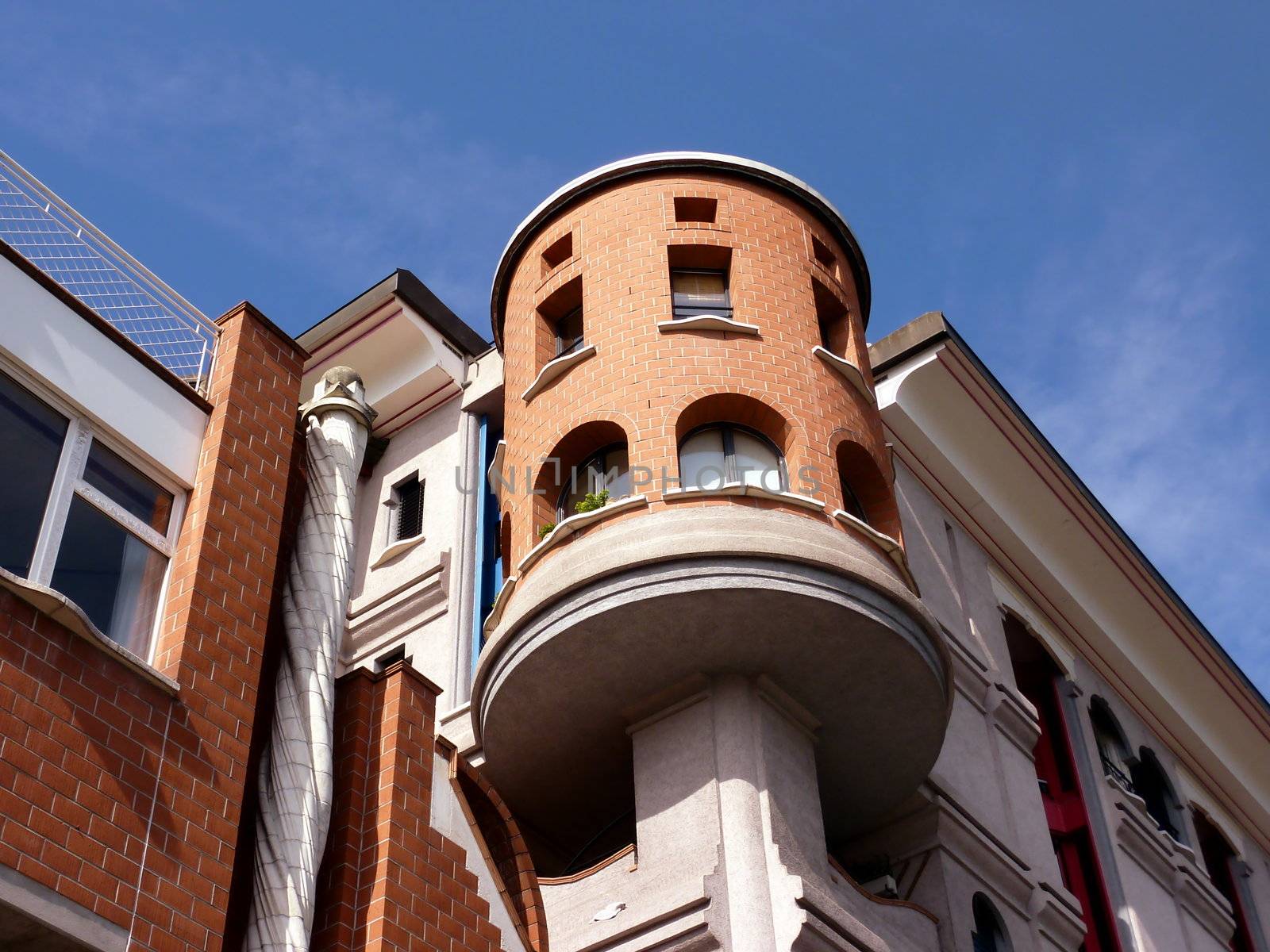 Eccentric tower of an orange building with blue sky