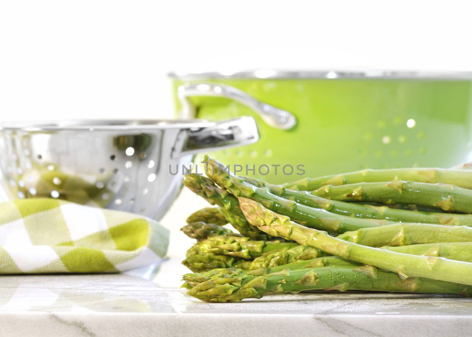 Green asparagus on marble table by Sandralise