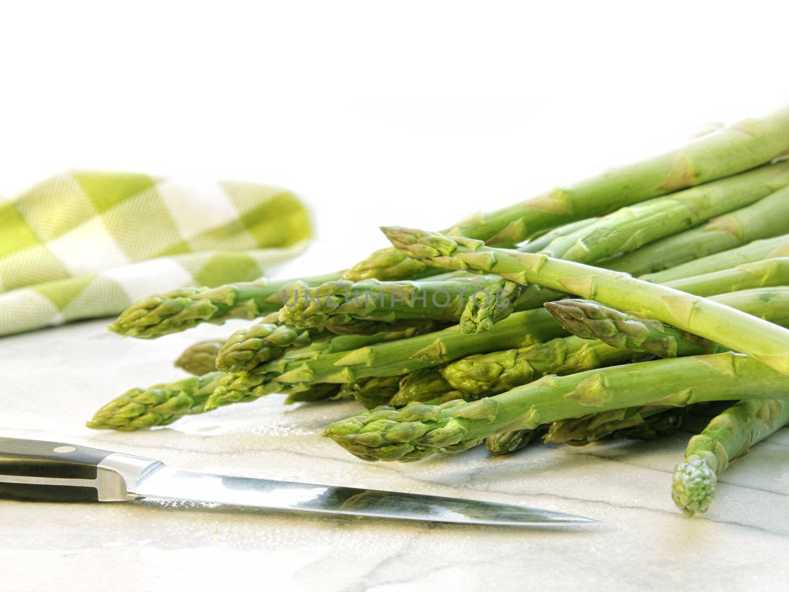 Freshly picked asparagus on white marble by Sandralise