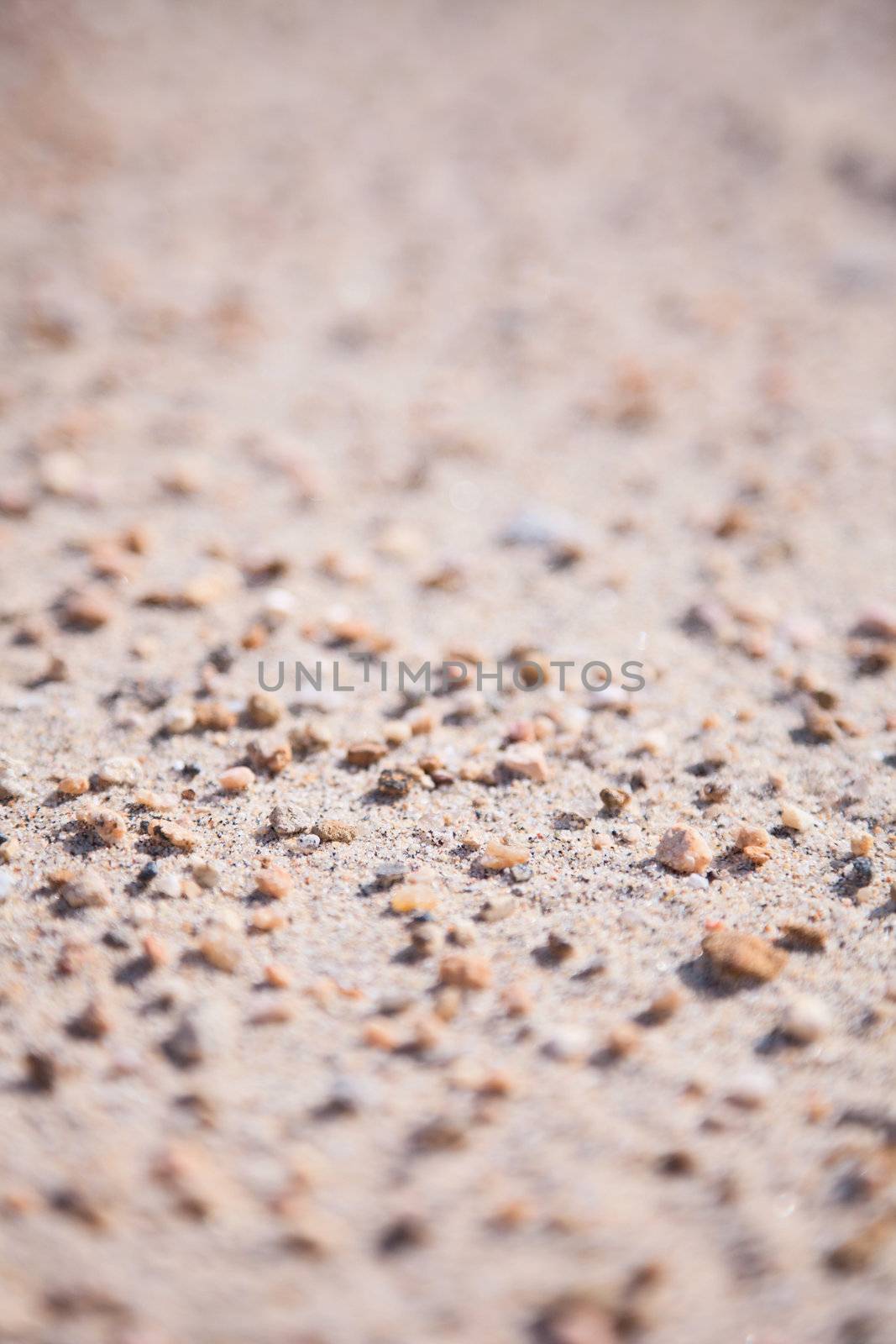 Surface of a sandy ground covered with small stones