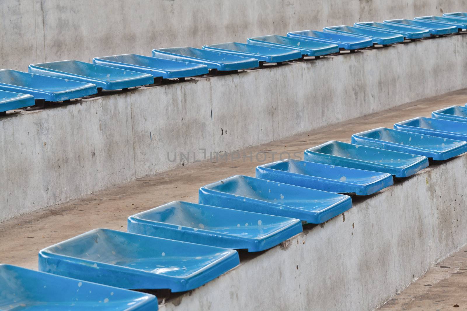 old plastic blue seats on stadium by FrameAngel