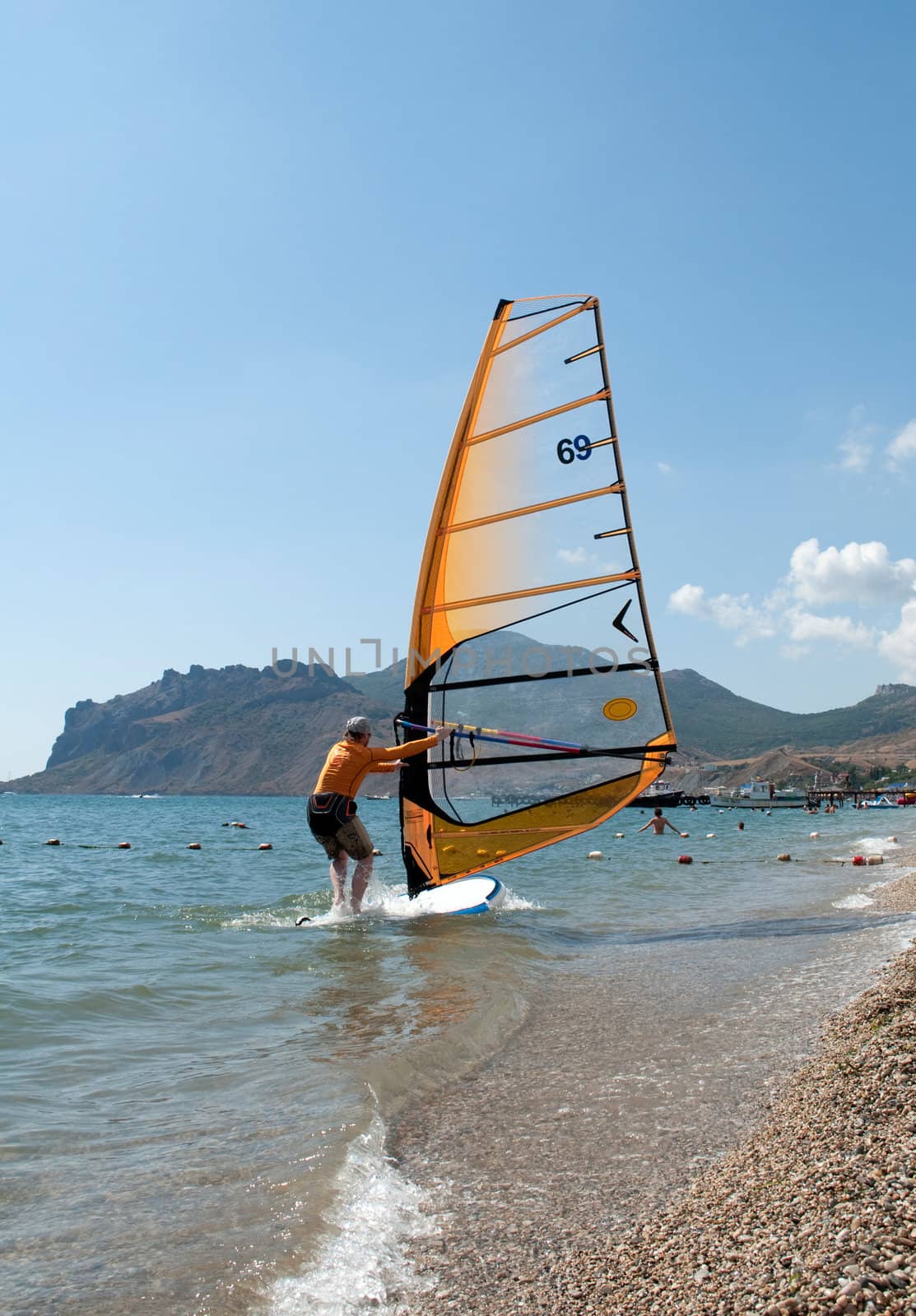 Windsurfer starting sailing on the waves 