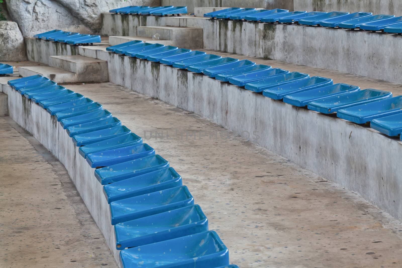 old plastic blue seats on stadium by FrameAngel