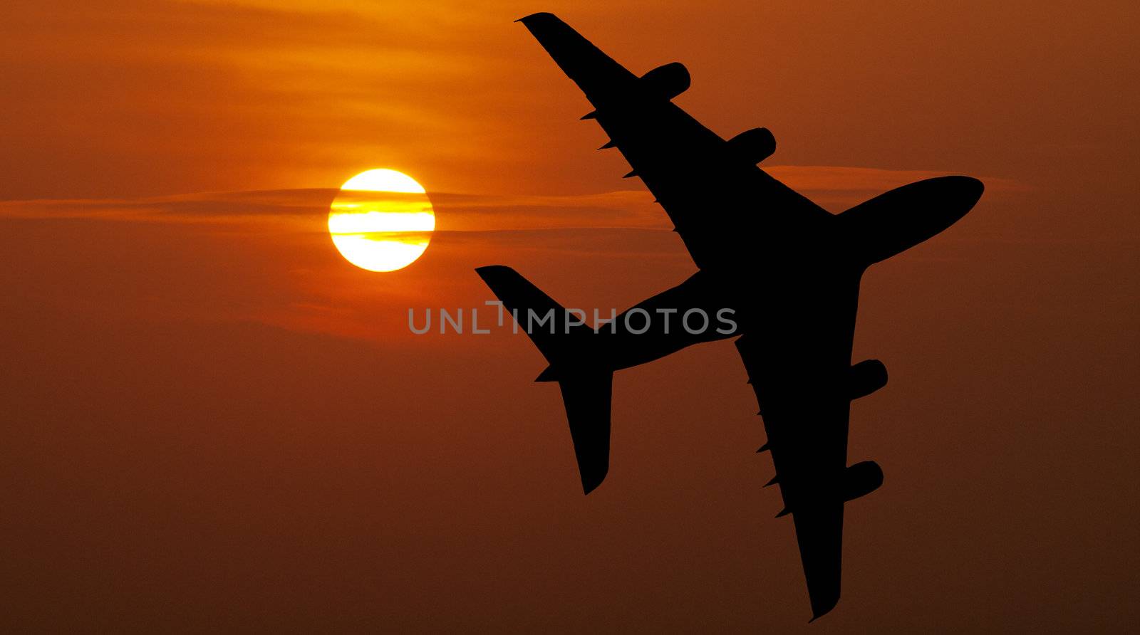 Large airliner flying over a beautiful  red sunset