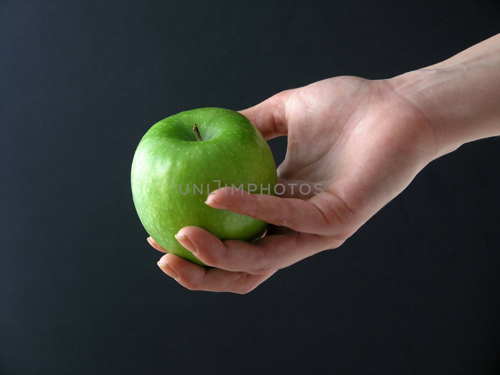 Apple in hand on black background