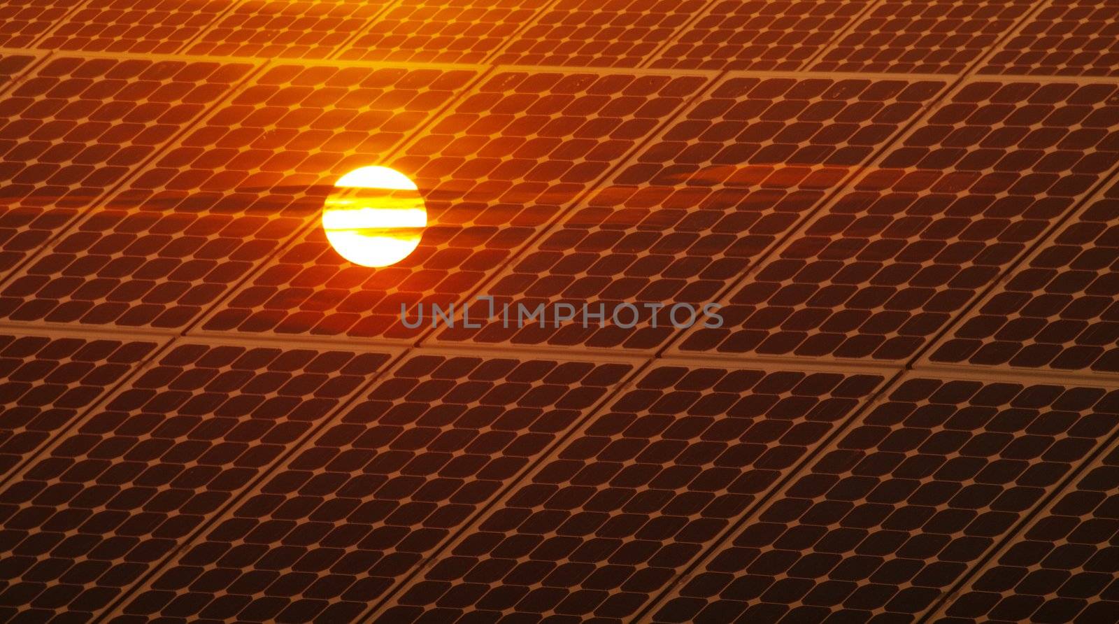 Renewable energy concept with photovoltaic panel and red sun