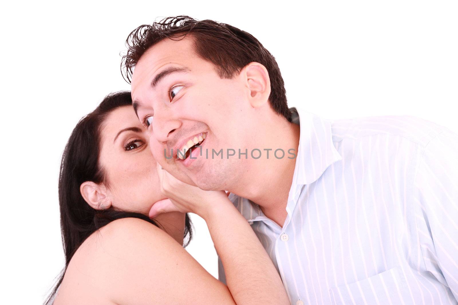 pretty girl talking secret to young man in his ear, man smiling by dacasdo