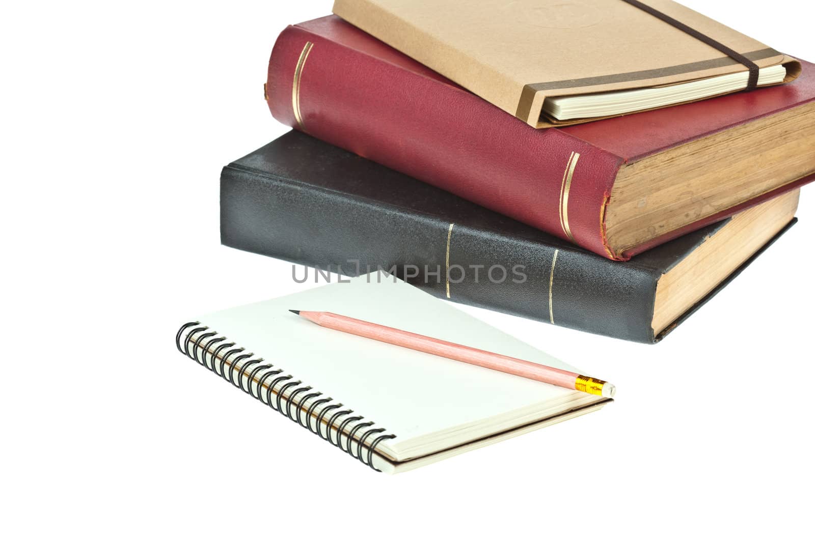 Pencil on, cream colored paper notebook and book as background
