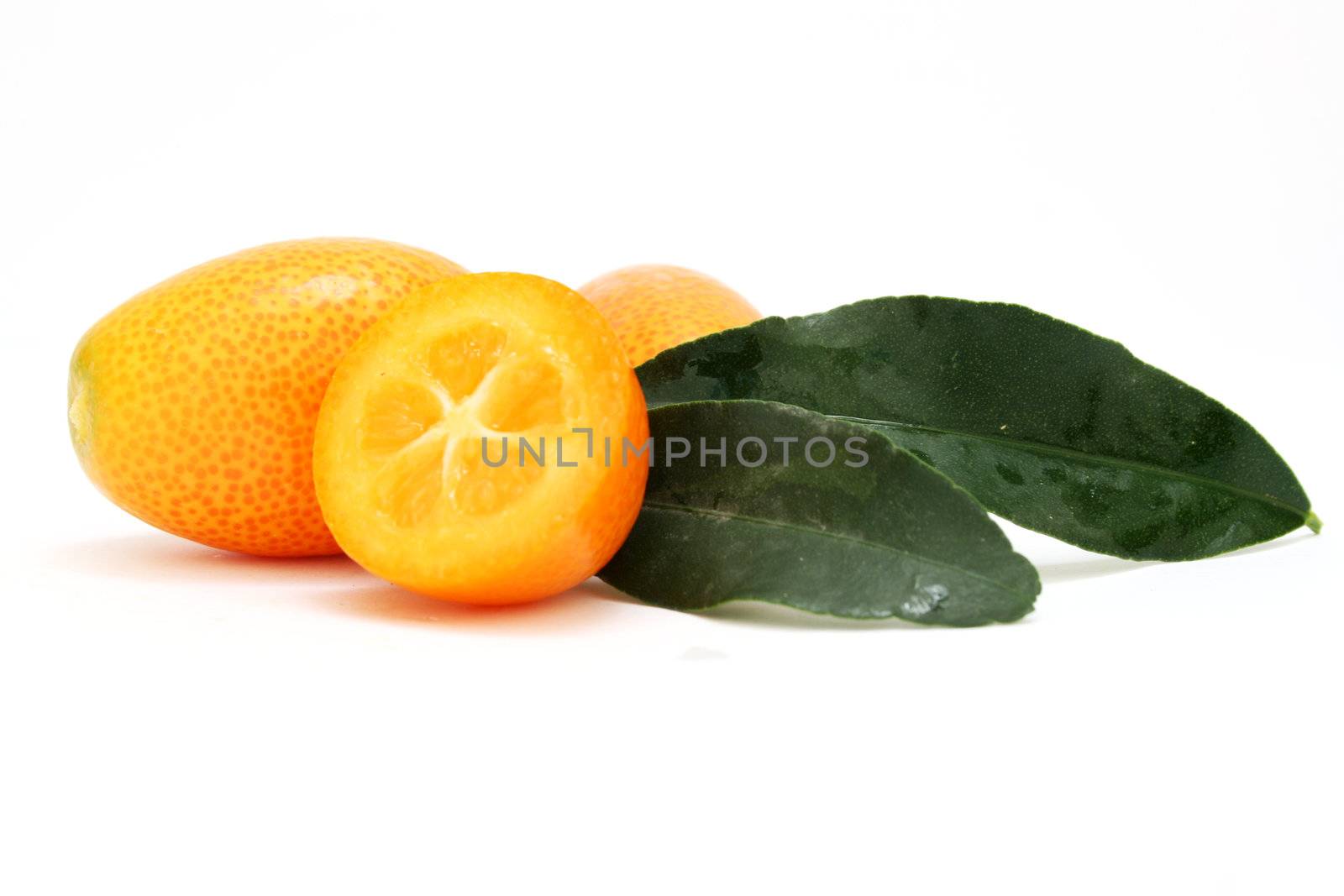 a few kumquats including a sliced one isolated on a white background