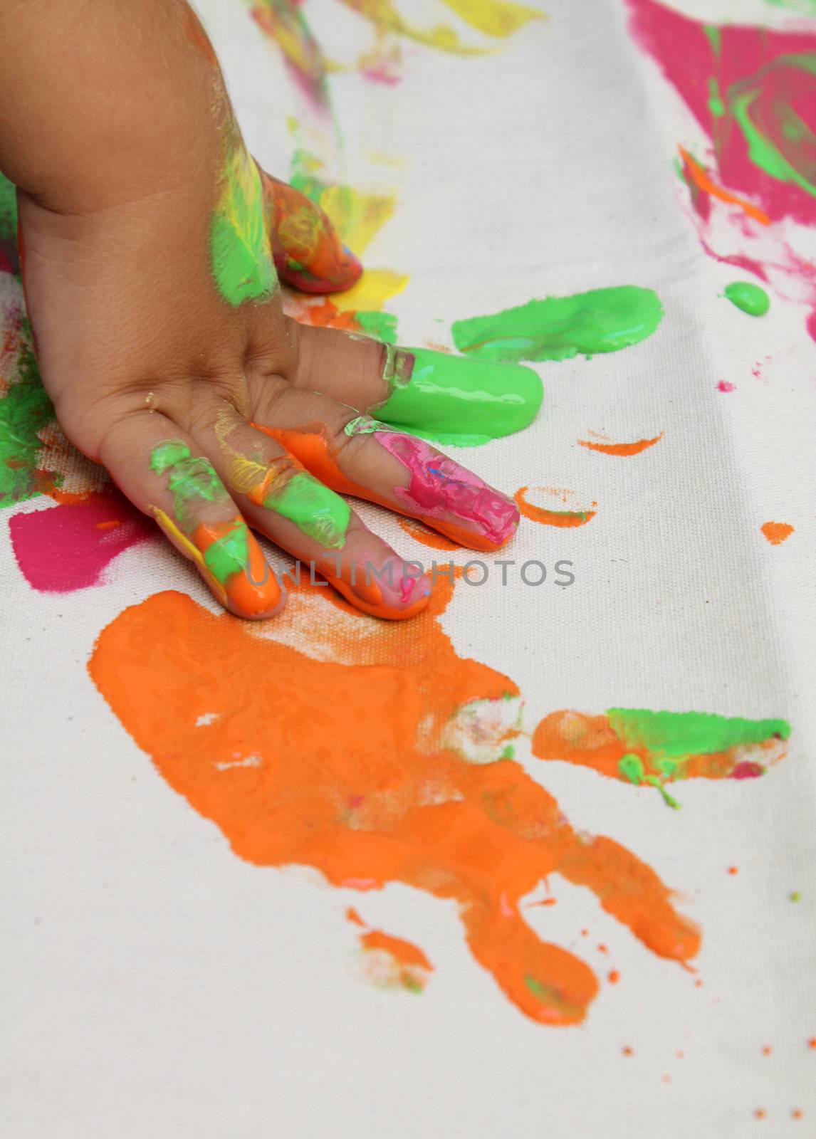 child's hand on canvas finger painting 