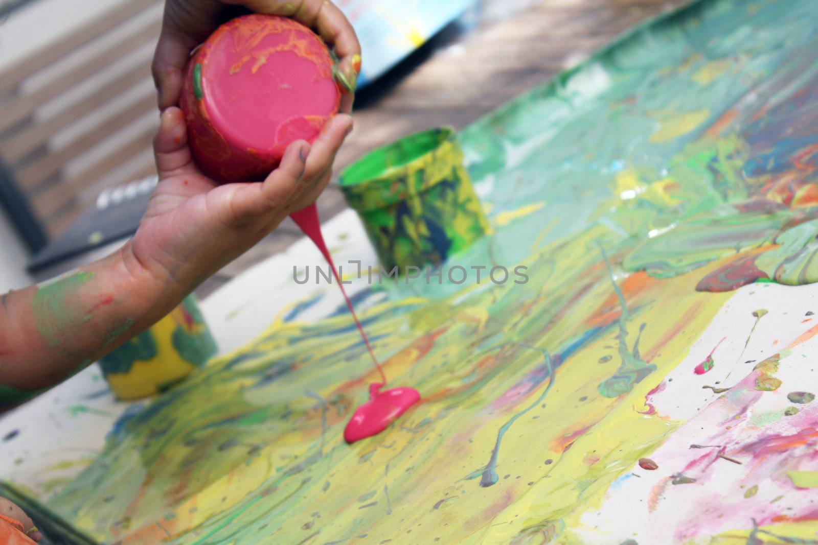 child painting on cancas with hands and tubs