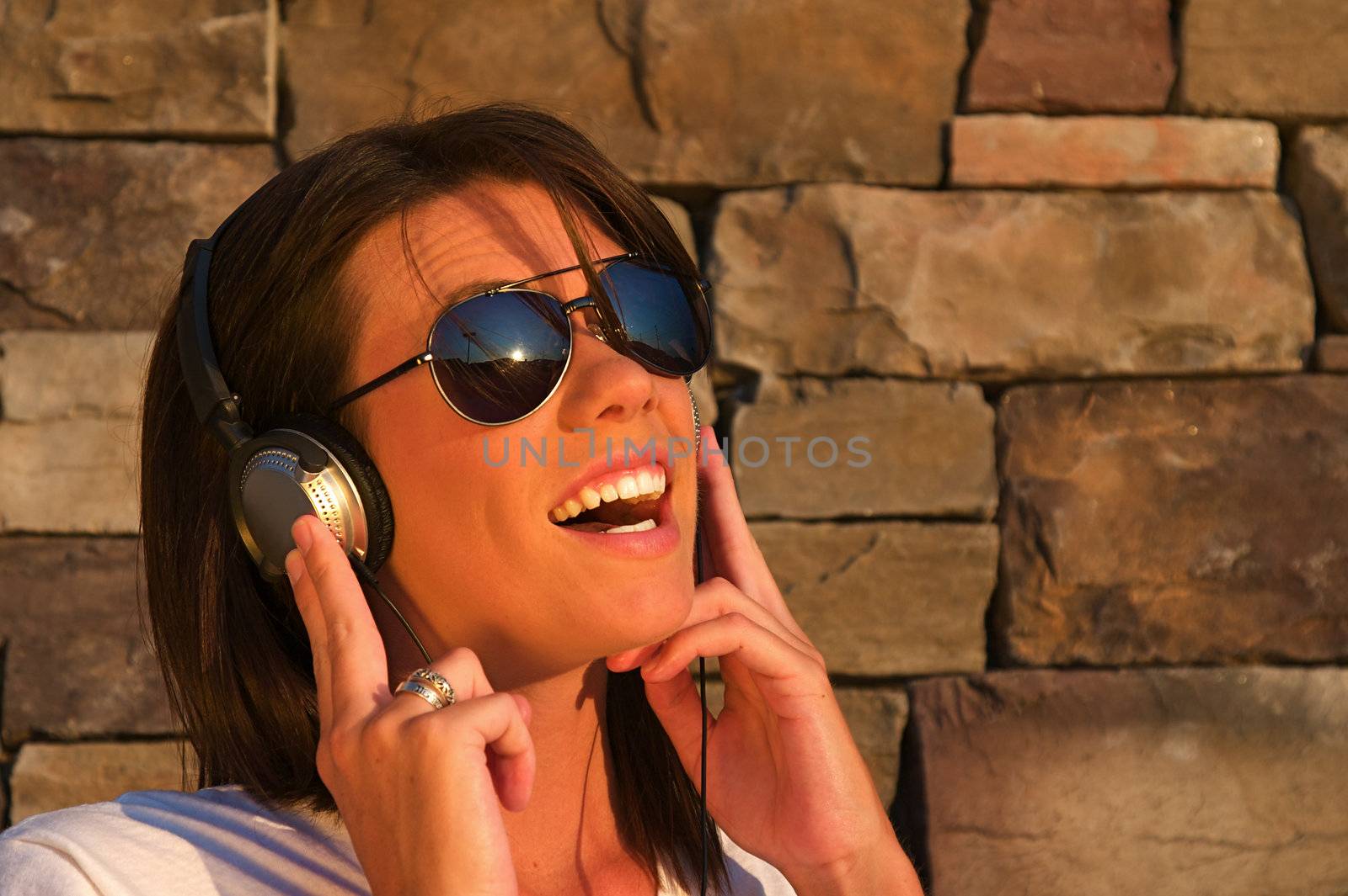 A cool young woman listens to music on some headphones