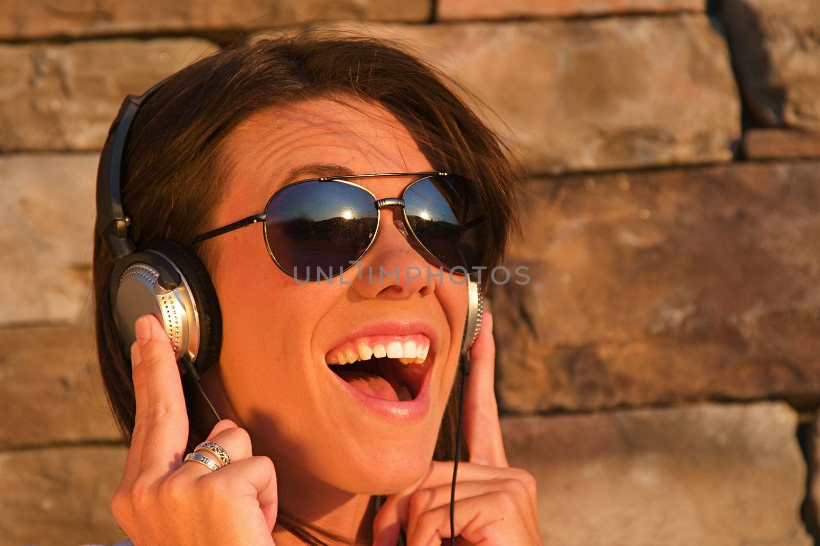 A cool young woman listens to music on some headphones