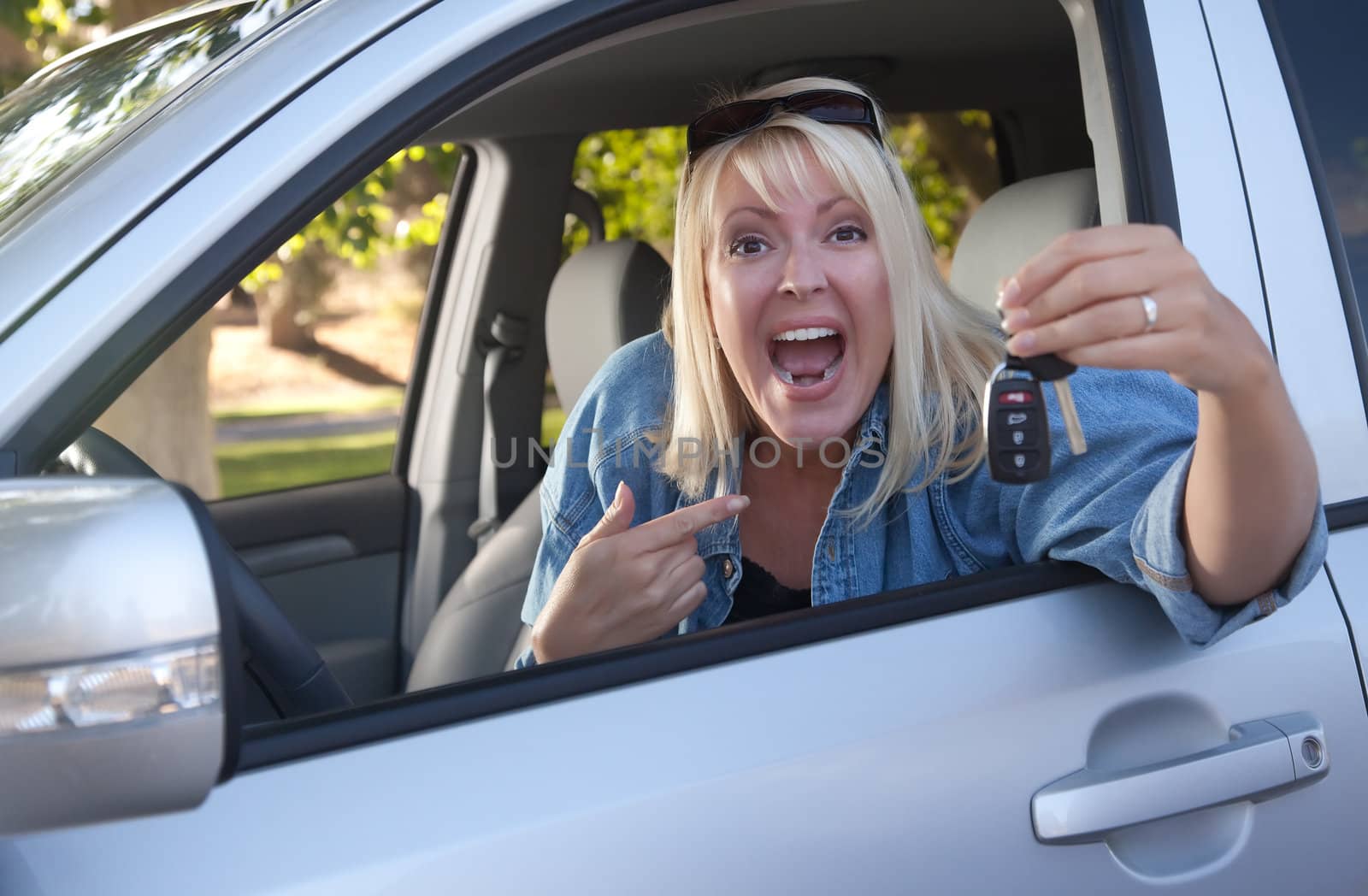 Attractive Happy Woman In New Car with Keys.