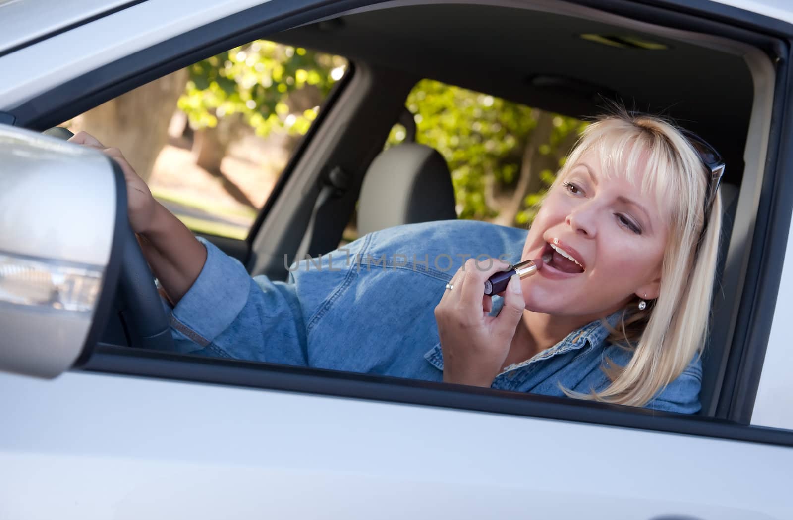 Woman Putting on Lipstick While Driving by Feverpitched