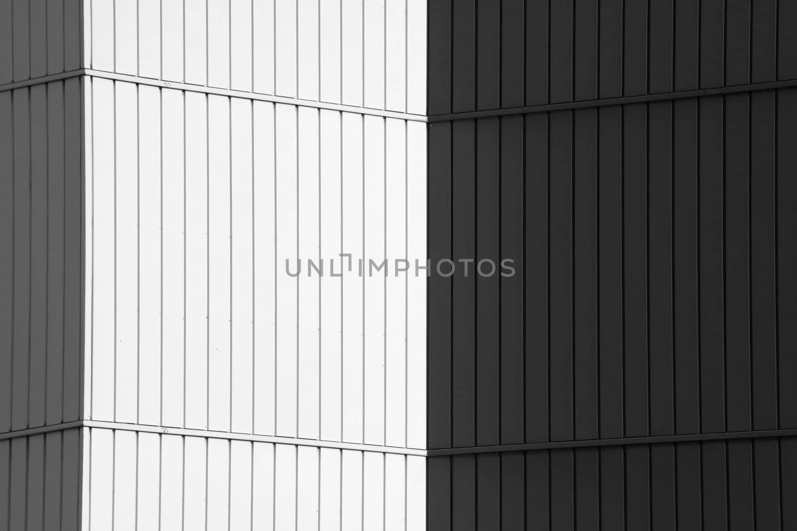Cornered wall of an office building covered with white and black panels.