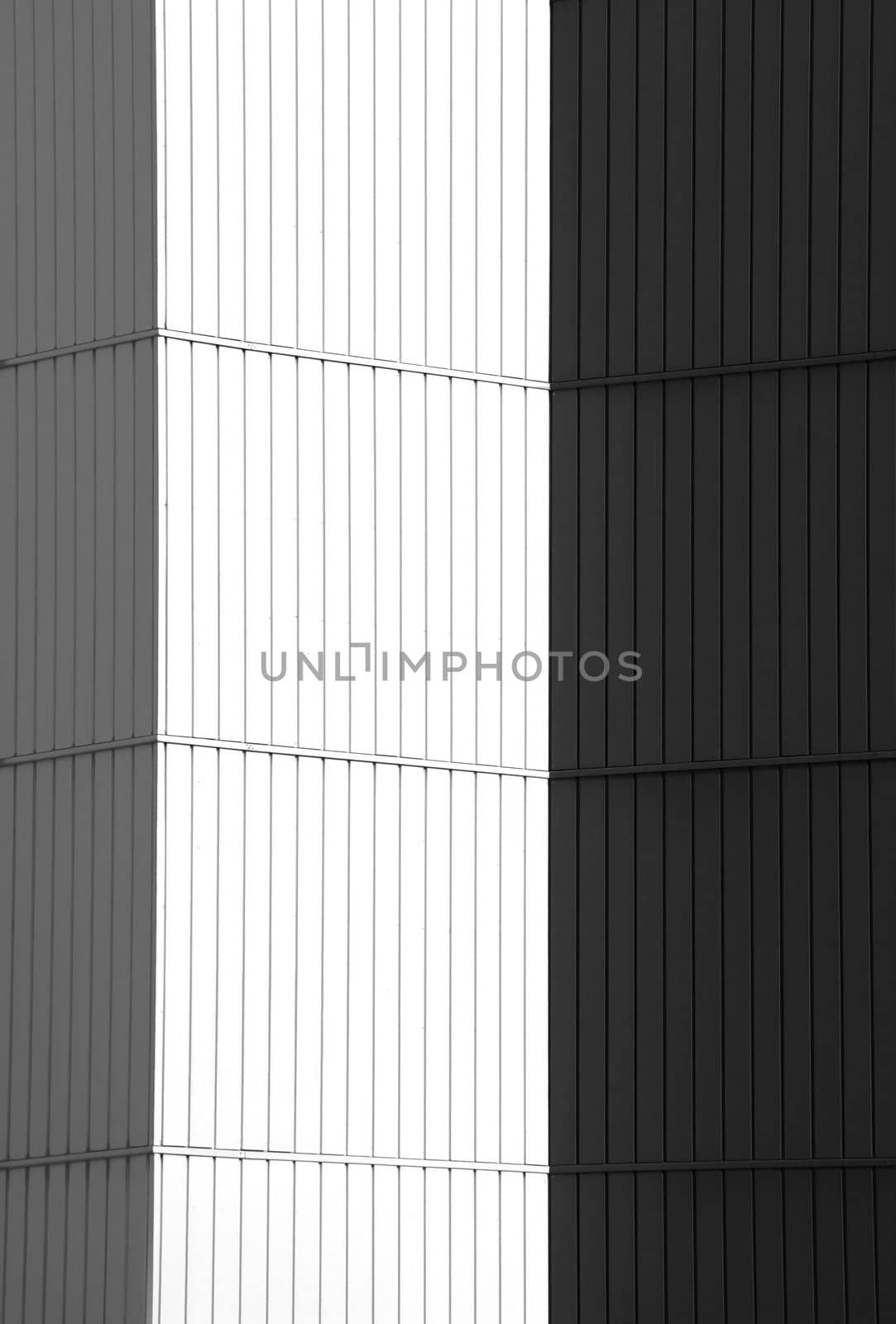 Cornered wall of an office building covered with white and black panels.