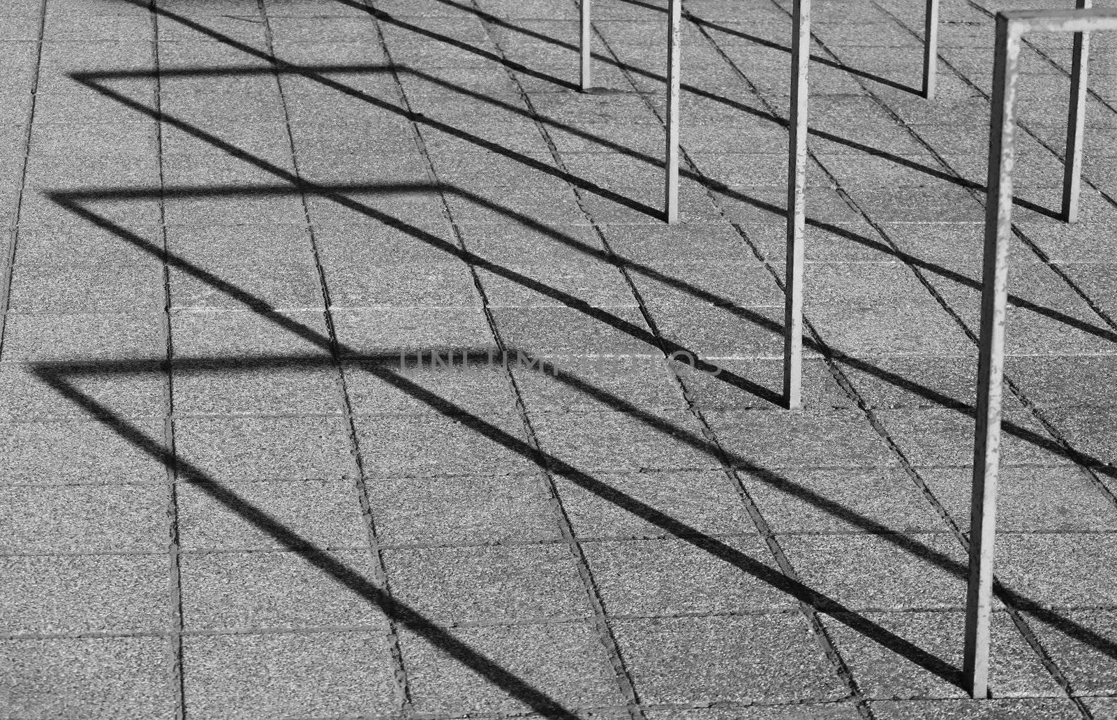 Empty bicycle stands are throwing long shadows on a very late afternoon.